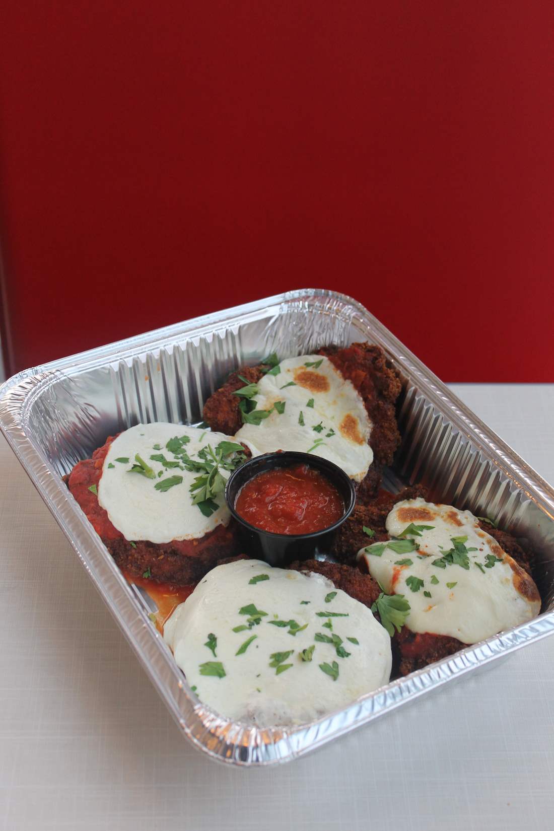 Chicken parm order from the family style catering menu. Fried chicken cutlets with mozzarella and tomato sauce.